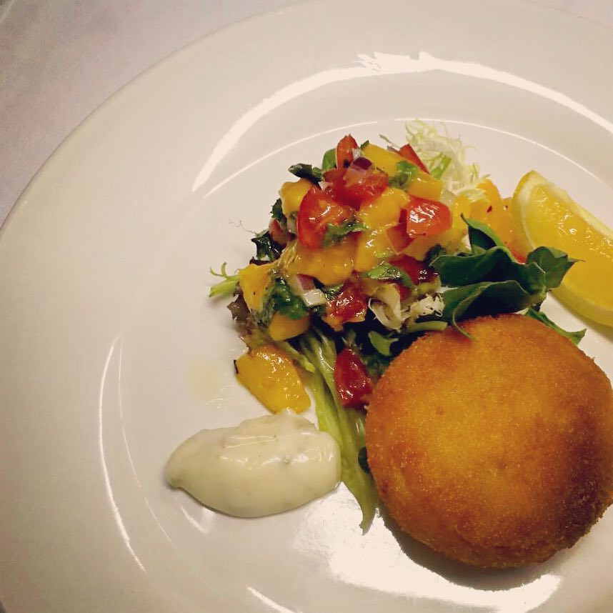 An image of Salmon fish cake with mango & red bell pepper salsa from Henry's in Stanley.